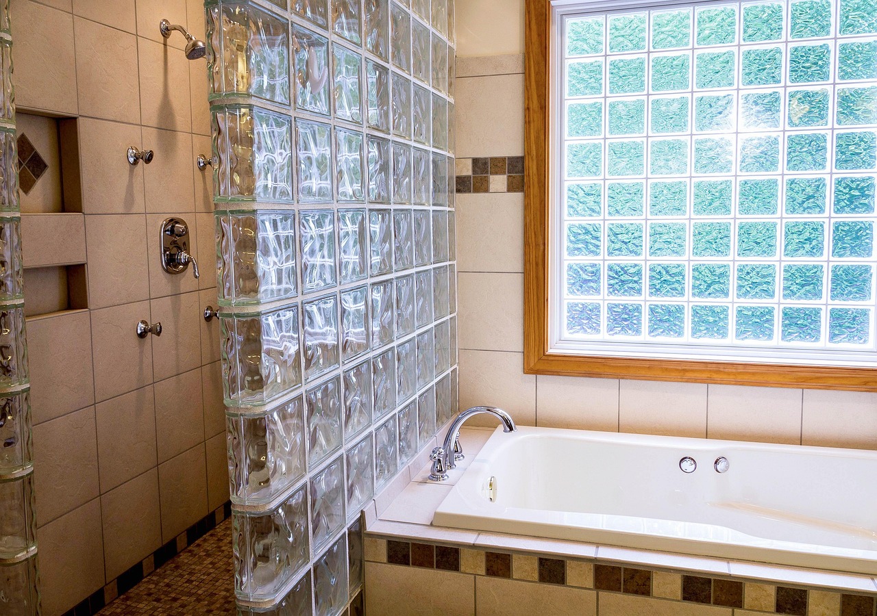 A clean tiled shower with the fan running
